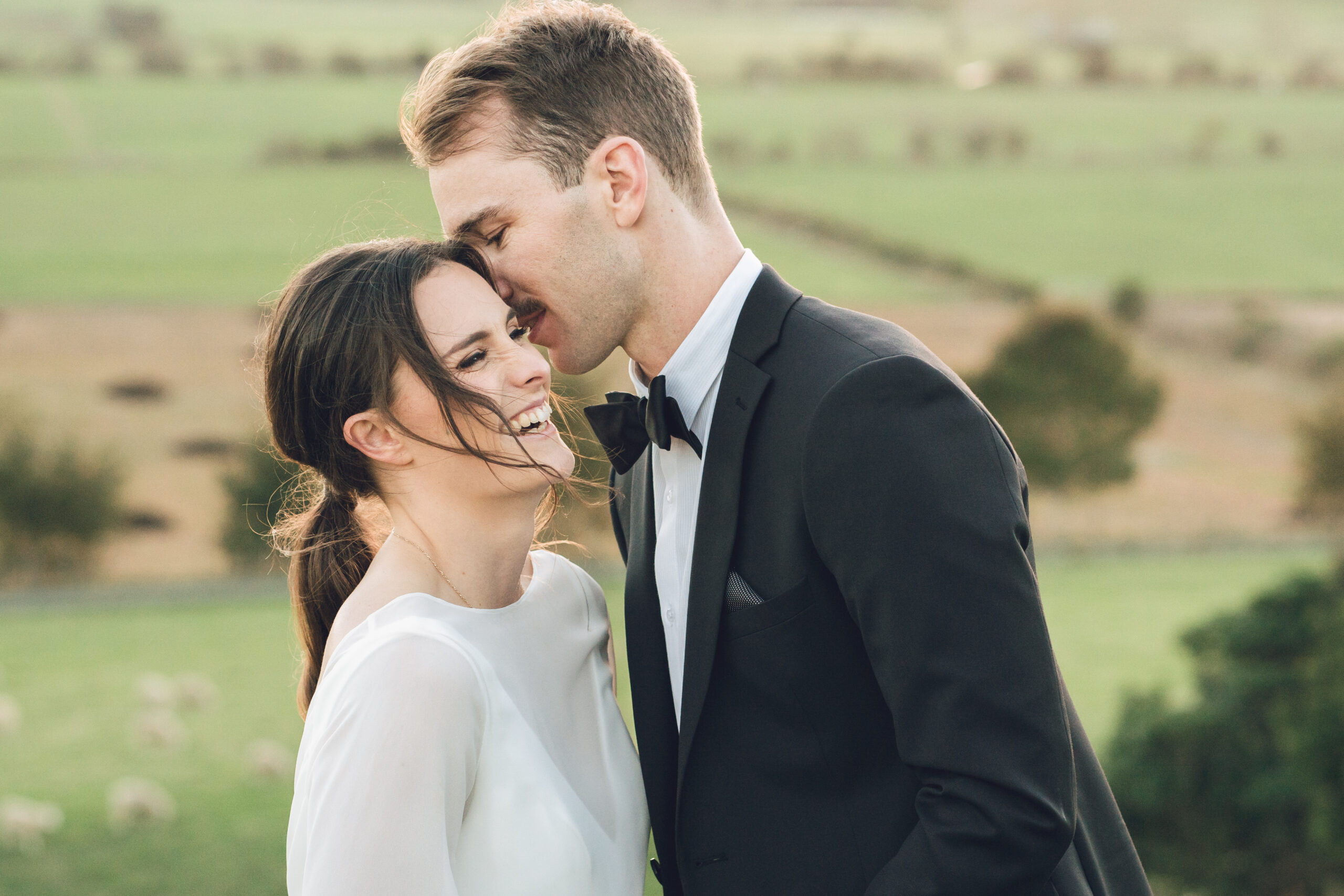 Auckland Couple in Cleveland on their Wedding Day. He leans in to give her a kiss on the cheek.