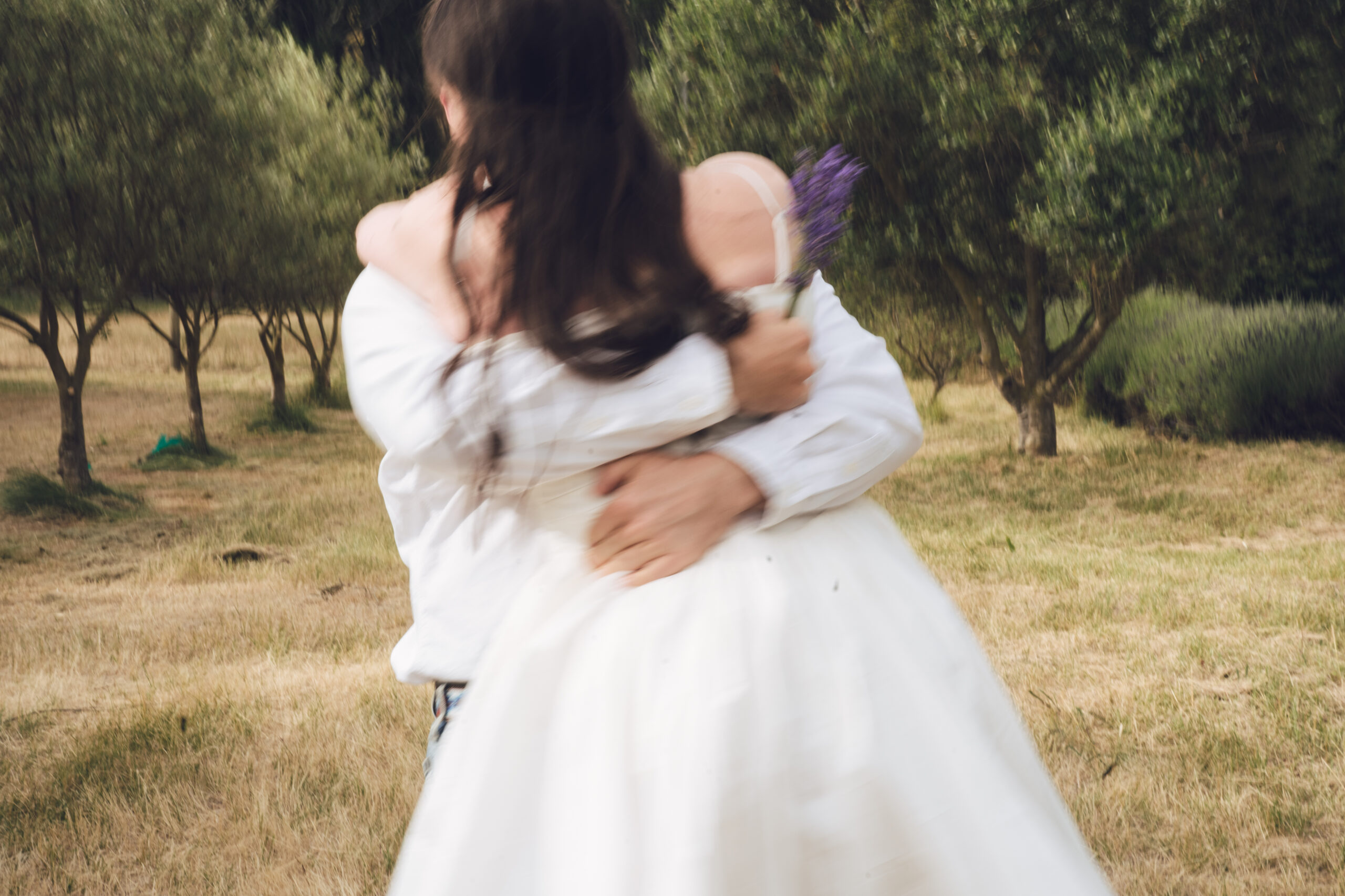 Tarras Wanaka Couple dancing in a field of olive trees on their wedding day.